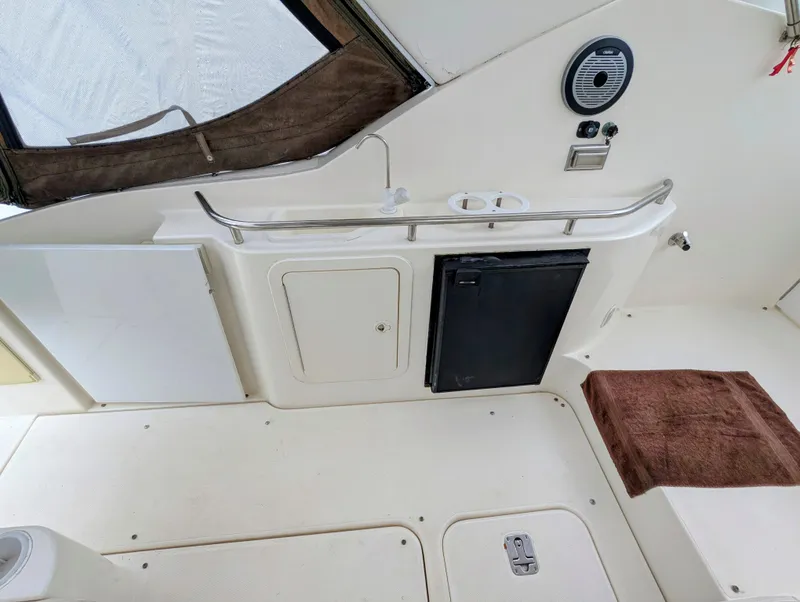 Slide: The Image of 2006 Cruisers Yachts 320 Express interior with sink, mini fridge, and storage compartments. - 9
