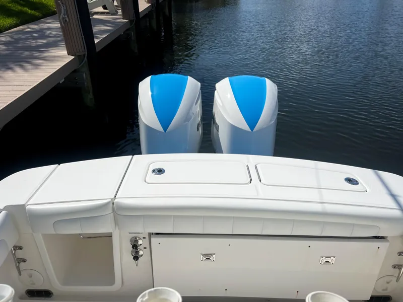 Slide: The Image of 2019 Regulator 25 boat with twin engines docked by the water. - 12
