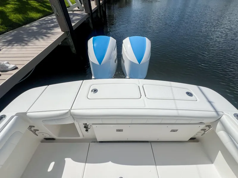 Slide: The Image of 2019 Regulator 25 boat with dual outboard engines docked by the water. - 14