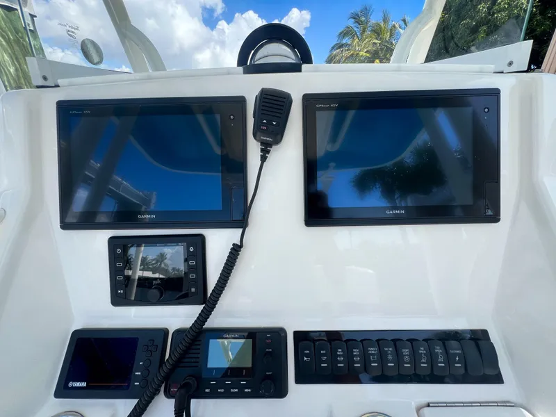 Slide: The Image of 2019 Regulator 25 boat dashboard with Garmin displays and control panel. - 15