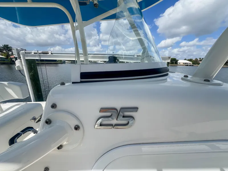 Slide: The Image of 2019 Regulator 25 boat detail with logo, blue canopy, and waterfront view. - 19