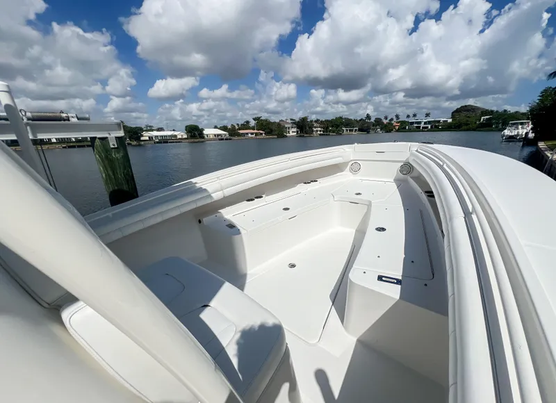 Slide: The Image of 2019 Regulator 25 boat with spacious seating, docked by a scenic waterfront. - 20