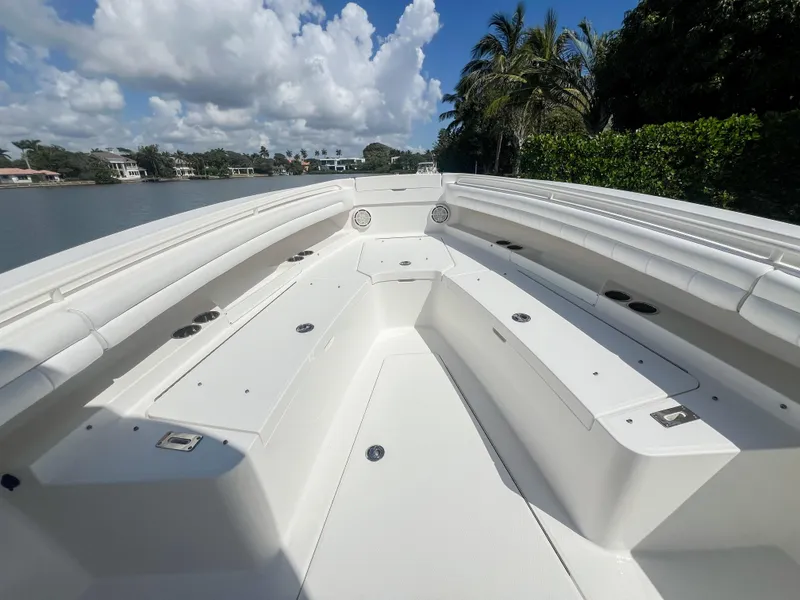 Slide: The Image of 2019 Regulator 25 boat deck with seating, under a clear blue sky. - 21