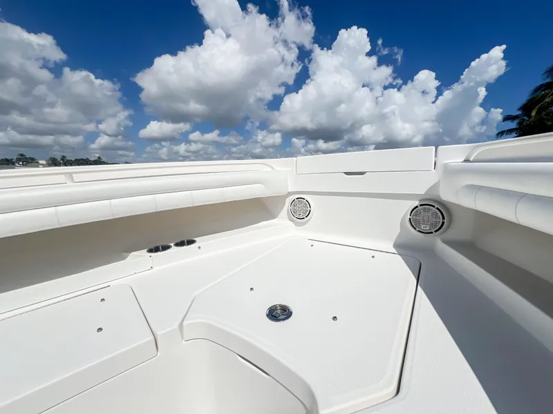 Slide: The Image of 2019 Regulator 25 boat interior with white seating under a blue sky with clouds. - 22