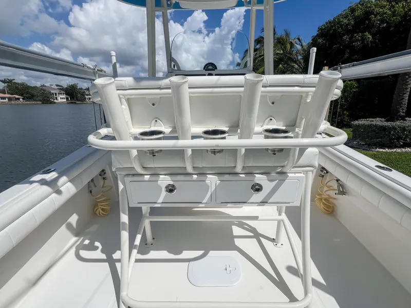 Slide: The Image of 2019 Regulator 25 boat interior with rod holders and storage, under a clear blue sky. - 26