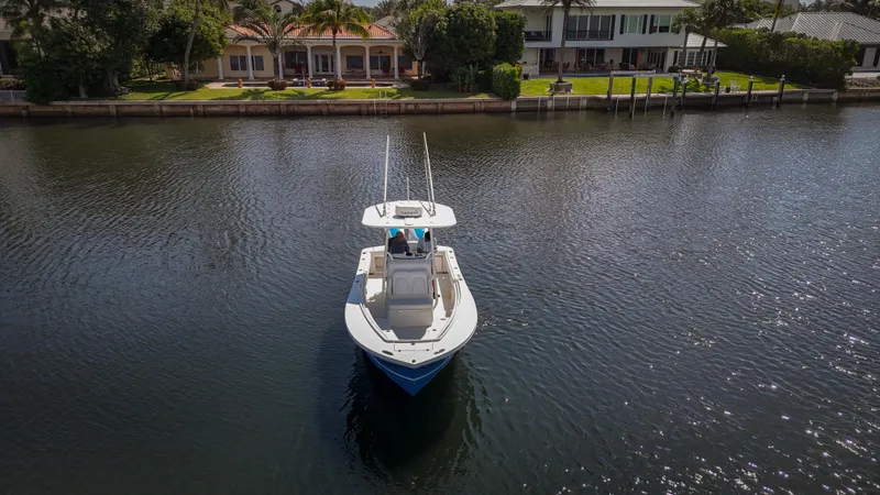 Slide: The Image of 2019 Regulator 25 boat on calm water near waterfront homes. - 3