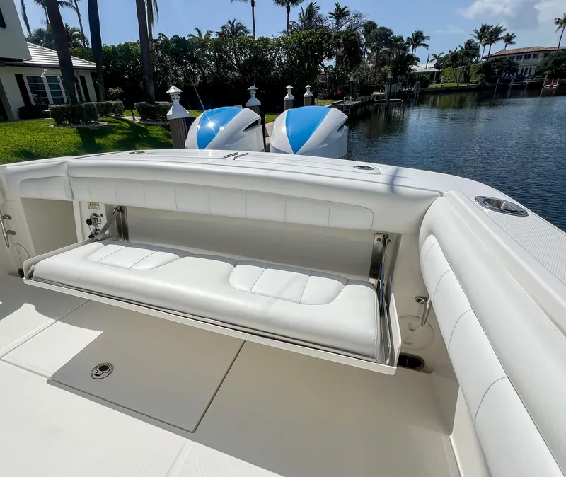 Slide: The Image of 2019 Regulator 25 boat with white seating, docked by a serene waterfront. - 30