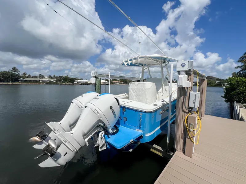 Slide: The Image of 2019 Regulator 25 boat docked with dual outboard engines under a partly cloudy sky. - 36