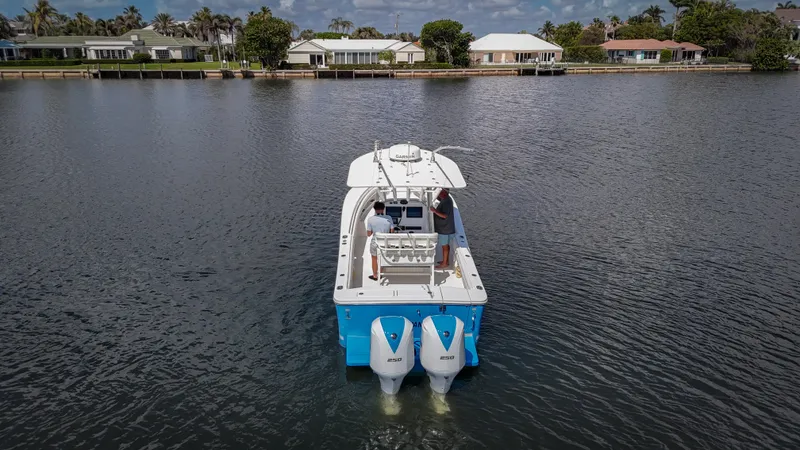 Slide: The Image of 2019 Regulator 25 boat with dual engines on a calm waterway. - 8