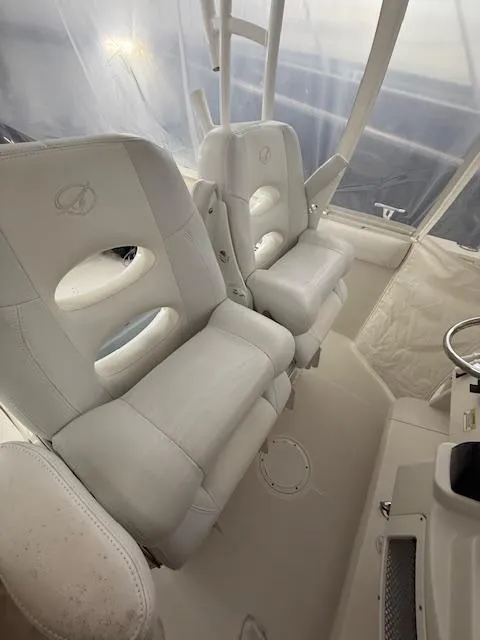 Slide: The Image of 2015 Sailfish 290 CC boat interior with white cushioned seats. - 6