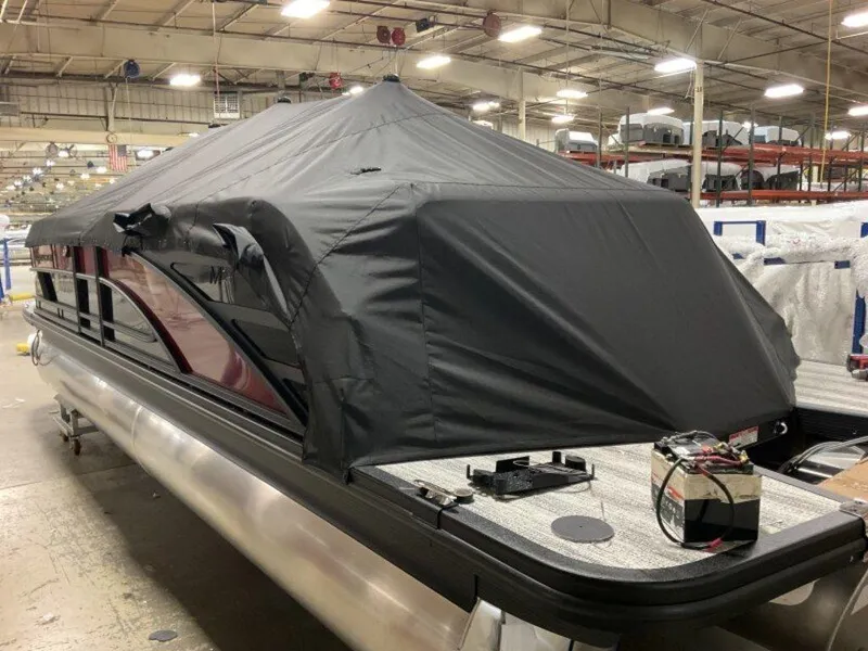 Slide: The Image of 2025 Bennington 24MLSE pontoon boat with cover in a warehouse setting. - 4