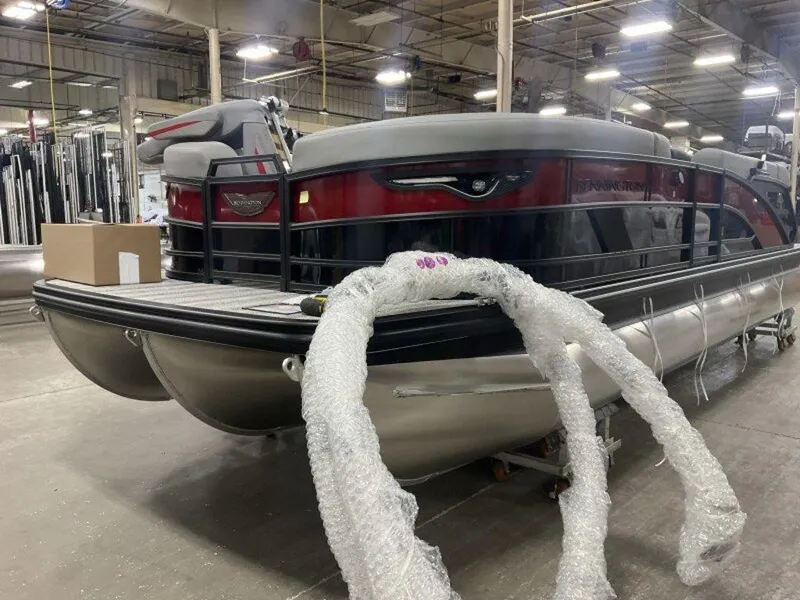 Slide: The Image of 2025 Bennington 24MLSE pontoon boat in a warehouse, partially wrapped in bubble wrap. - 5
