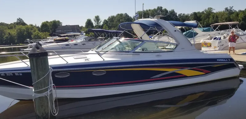 Slide: The Image of 2006 Formula 330 SS boat docked at a marina with other boats nearby. - 1