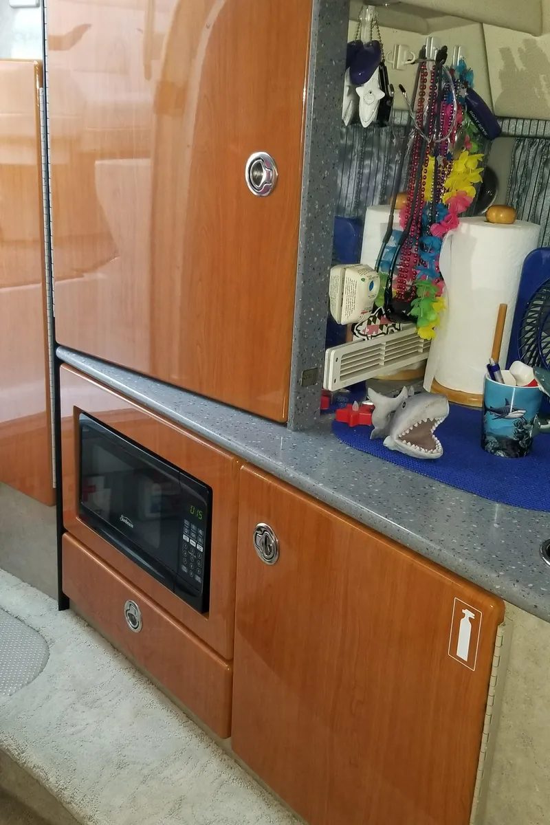 Slide: The Image of 2006 Formula 330 SS interior with wooden cabinets and a microwave in the kitchenette area. - 16