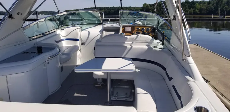 Slide: The Image of 2006 Formula 330 SS boat interior with seating and table, docked by a calm lake. - 7