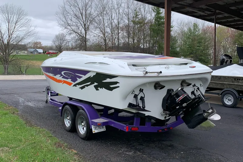 Slide: The Image of 2003 Baja 24 H2X Boss boat on a trailer, featuring vibrant graphics and dual engines. - 3