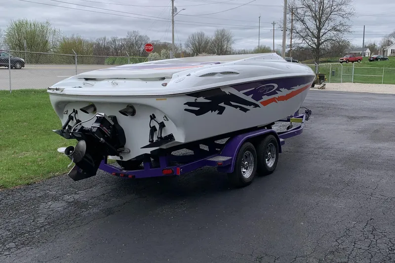 Slide: The Image of 2003 Baja 24 H2X Boss boat on trailer, parked on asphalt. - 4