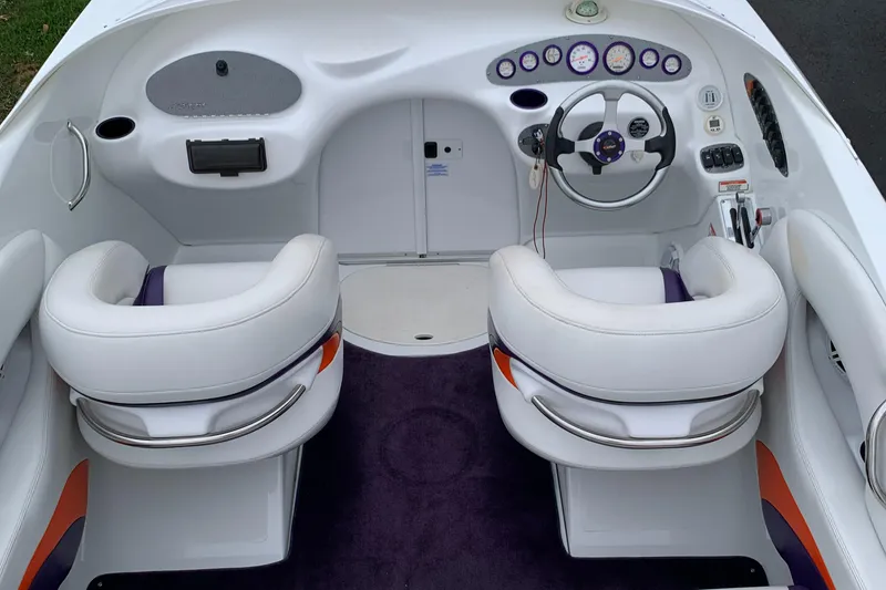 Slide: The Image of 2003 Baja 24 H2X Boss boat interior with white seats and modern dashboard. - 5