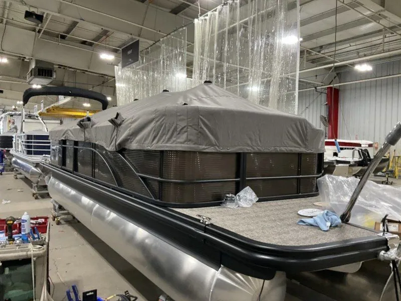 Slide: The Image of 2025 Bennington SX L-Bench 23 SXL pontoon boat in a warehouse setting. - 10