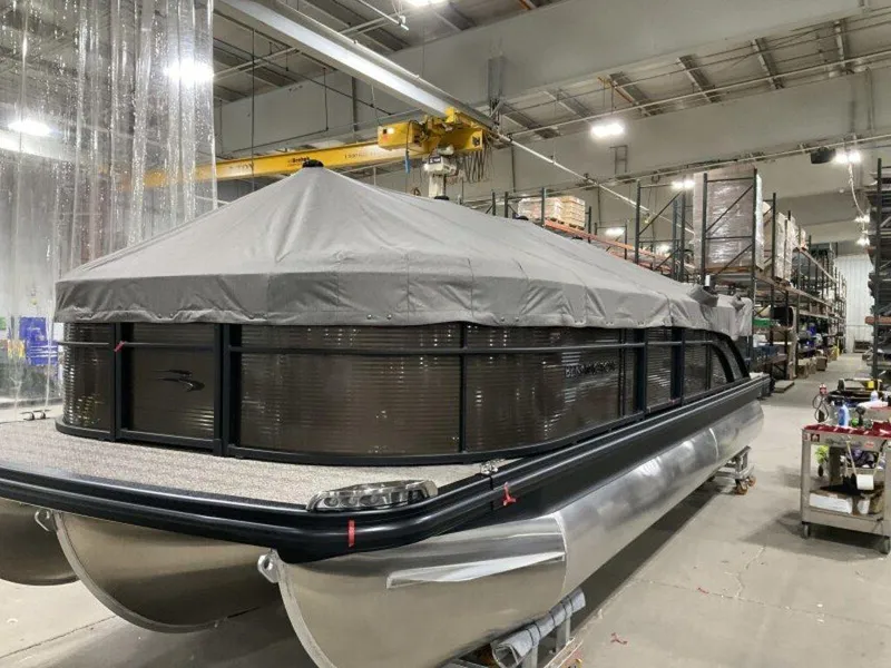 Slide: The Image of 2025 Bennington SX L-Bench 23 SXL pontoon boat in a warehouse setting. - 12