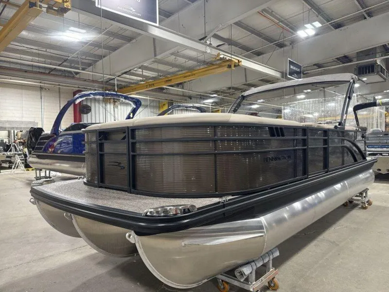 Slide: The Image of 2025 Bennington SX L-Bench 23 SXL pontoon boat in a factory setting. - 3