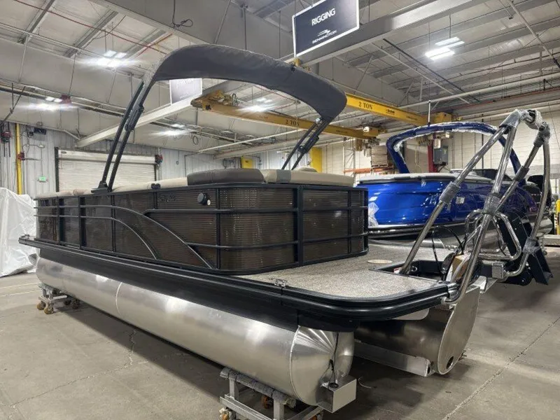 Slide: The Image of 2025 Bennington SX L-Bench 23 SXL pontoon boat in a warehouse setting. - 5