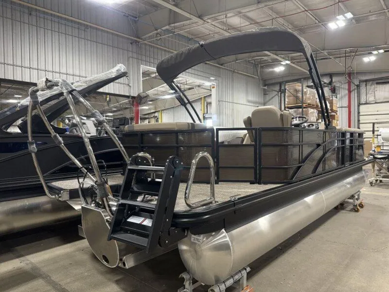 Slide: The Image of 2025 Bennington SX L-Bench 23 SXL pontoon boat in a warehouse setting. - 6