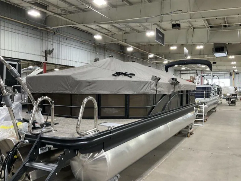 Slide: The Image of 2025 Bennington SX L-Bench 23 SXL pontoon boat in a warehouse, covered and ready for transport. - 9