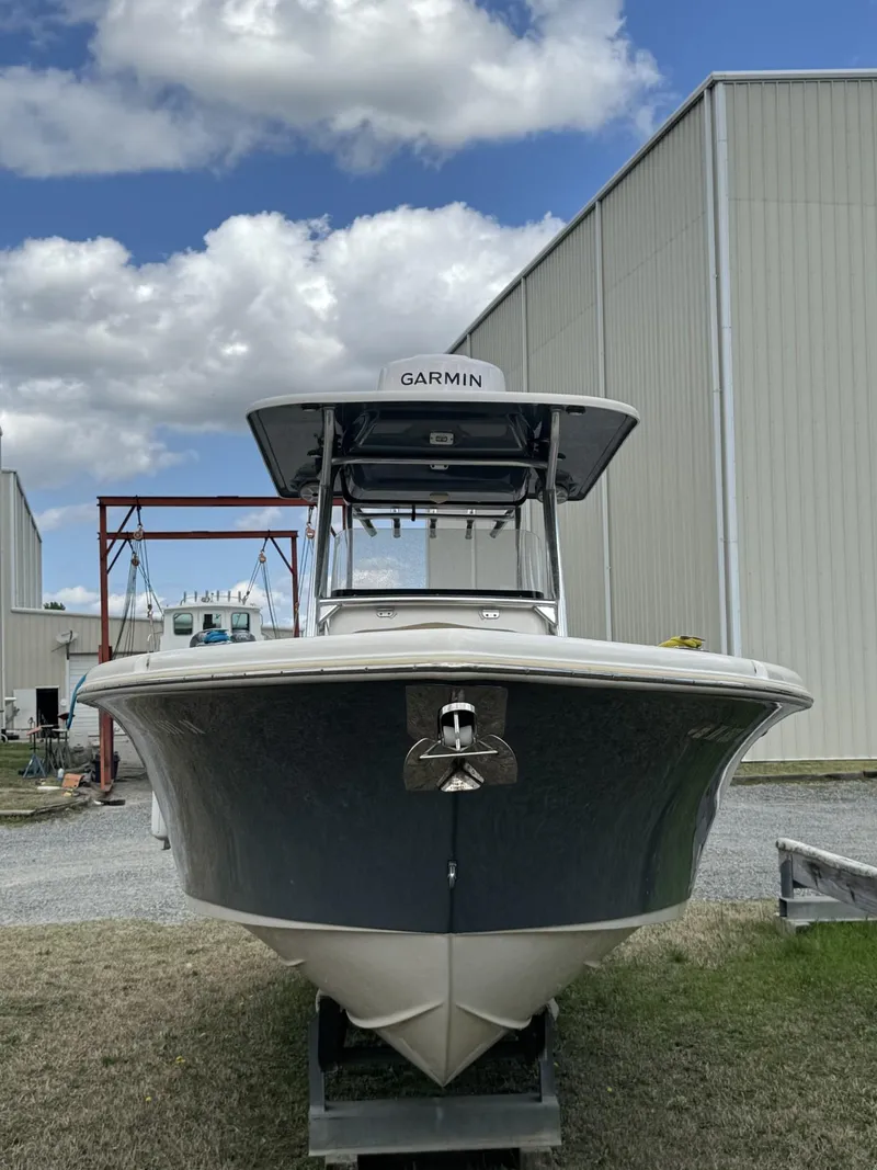 Slide: The Image of 2018 Key West 263 FS boat with Garmin equipment, docked near a warehouse under a cloudy sky. - 3