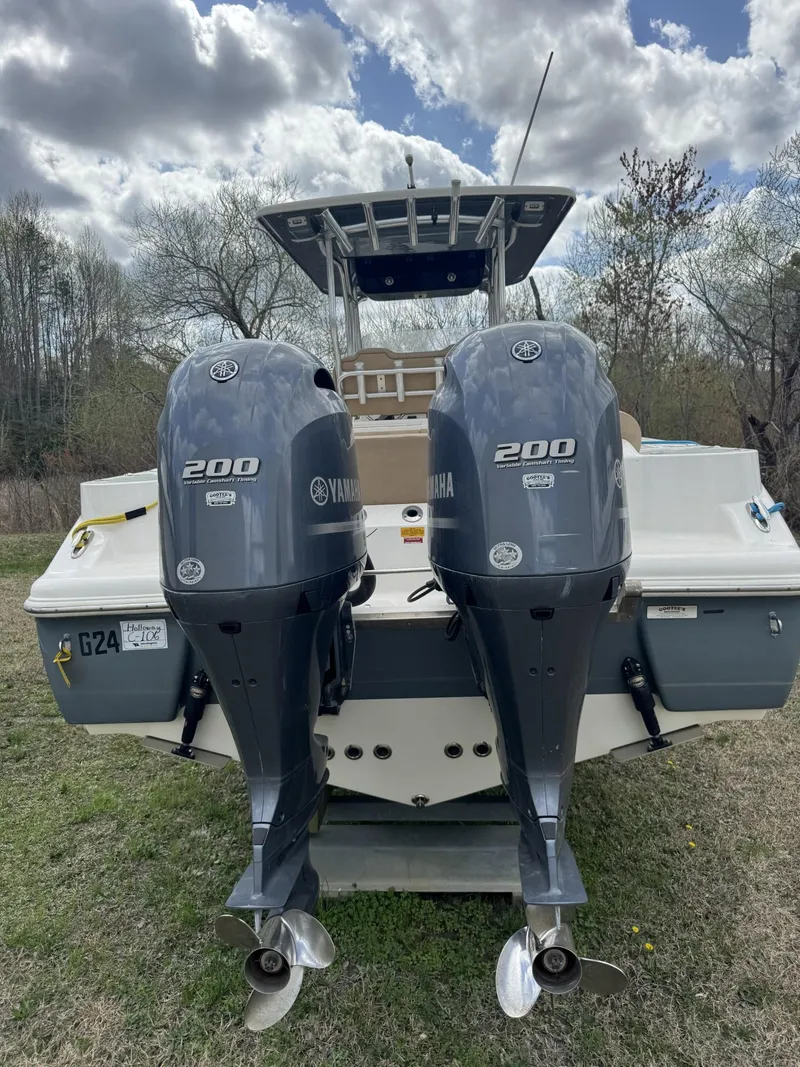 Slide: The Image of 2018 Key West 263 FS boat with dual Yamaha 200 engines, parked on grass. - 4