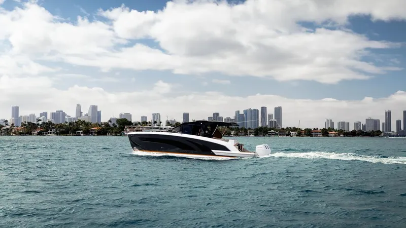 Slide: The Image of 2025 Hanover 387 boat cruising on water with city skyline in background. - 2