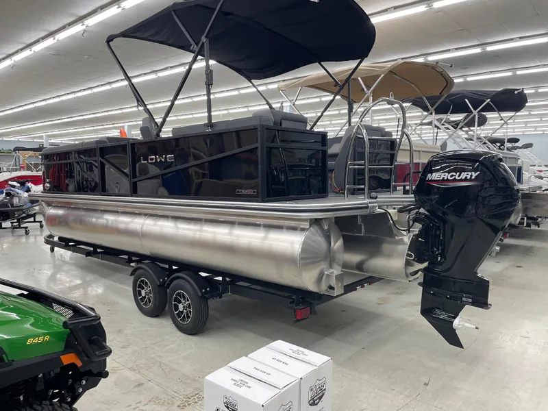 Slide: The Image of 2025 Lowe LS230W pontoon boat with Mercury outboard motor in showroom. - 1