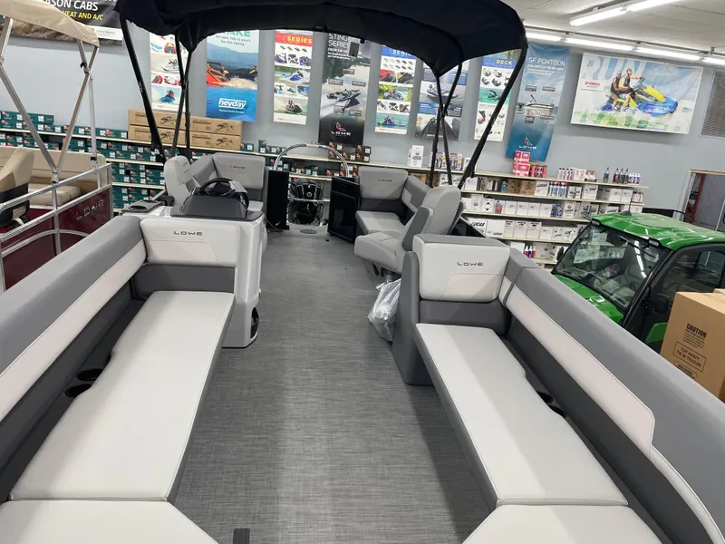 Slide: The Image of Lowe LS230W 2025 pontoon boat interior with gray seating in showroom. - 9