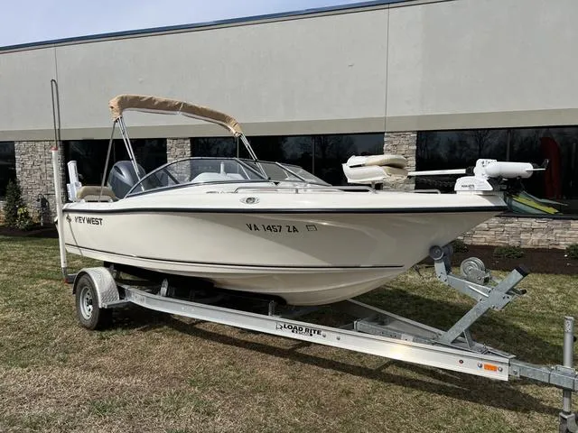 Slide: The Image of 2018 Key West 186DC boat on trailer, parked outdoors near a building. - 1