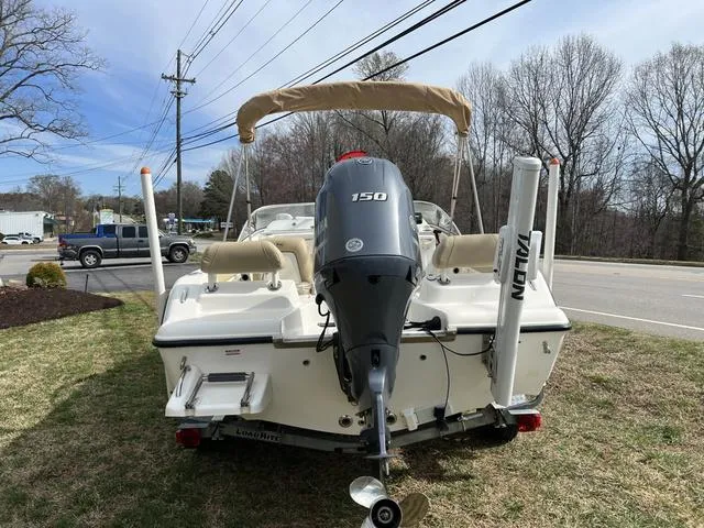 Slide: The Image of 2018 Key West 186DC boat with 150 HP engine, parked on grass near a road. - 4