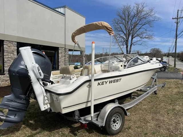 Slide: The Image of 2018 Key West 186DC boat on trailer, parked outdoors near a building. - 5