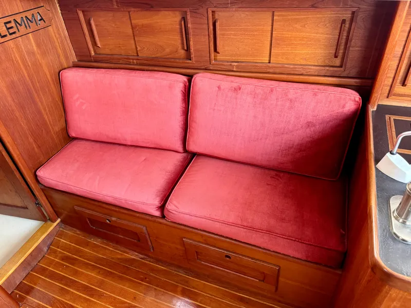 Slide: The Image of Red cushioned seating in a 1981 Bristol 29.9 boat interior with wooden paneling. - 14