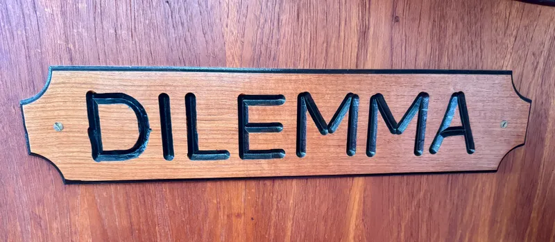 Slide: The Image of Wooden nameplate with "DILEMMA" engraved, on a 1981 Bristol 29.9 boat. - 26