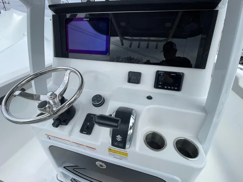 Slide: The Image of 2025 Sea Pro 245 Sandbar boat console with steering wheel and electronic controls. - 13