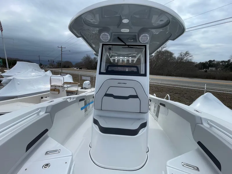 Slide: The Image of 2025 Sea Pro 245 Sandbar boat, sleek design, spacious deck, overcast sky background. - 14