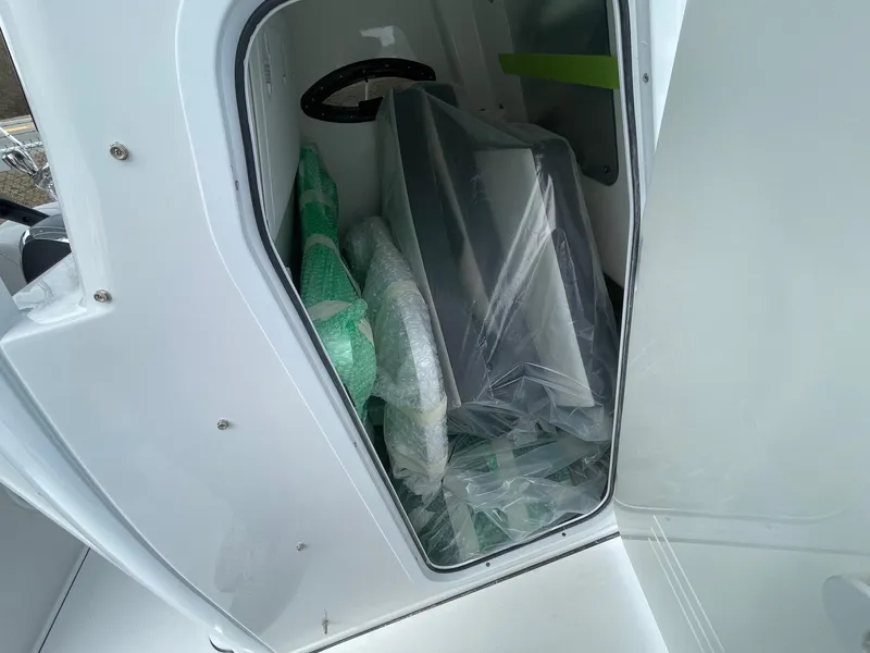 Slide: The Image of Storage compartment of 2025 Sea Pro 245 Sandbar boat, containing wrapped items. - 26