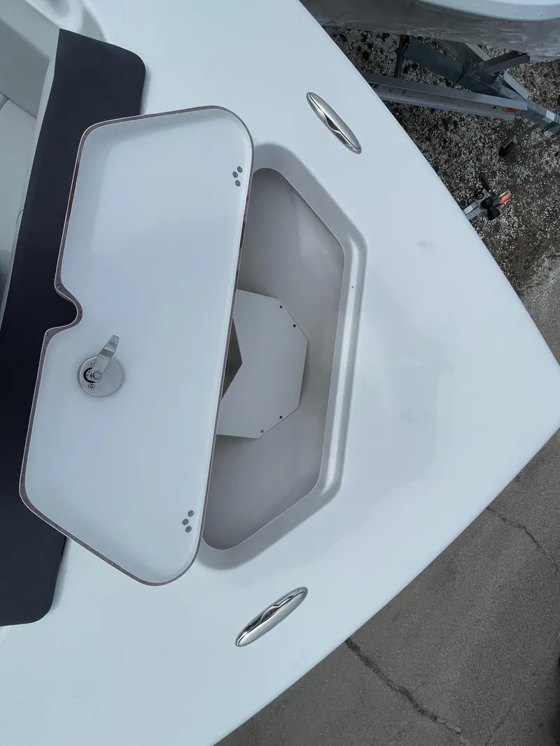 Slide: The Image of 2025 Sea Pro 245 Sandbar boat storage compartment with open lid, showcasing interior space. - 30