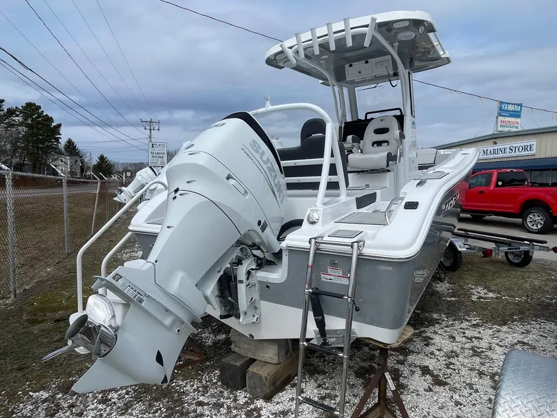 Slide: The Image of 2025 Sea Pro 245 Sandbar boat with outboard motor, parked outdoors. - 7