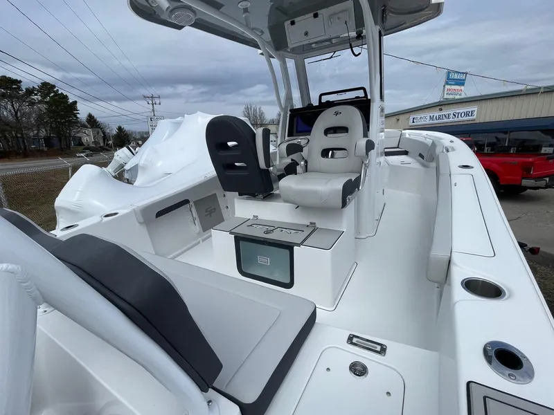 Slide: The Image of 2025 Sea Pro 245 Sandbar boat interior with seating and console, displayed outdoors. - 8