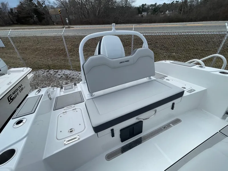 Slide: The Image of 2025 Sea Pro 245 Sandbar boat, rear seating and deck view, parked outdoors. - 9