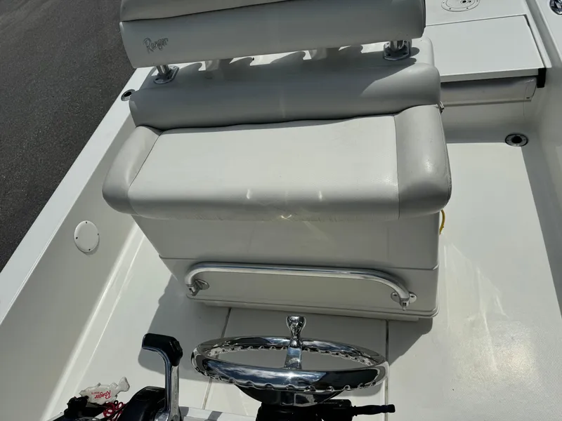 Slide: The Image of 2010 Ranger 2310 boat interior with white cushioned seating and steering wheel. - 11