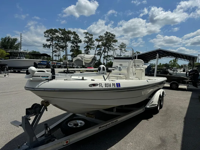 Slide: The Image of 2010 Ranger 2310 boat on trailer under a sunny sky in a parking area. - 3