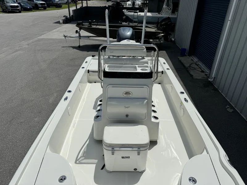 Slide: The Image of 2010 Ranger 2310 boat with center console and cooler, parked near a storage facility. - 9