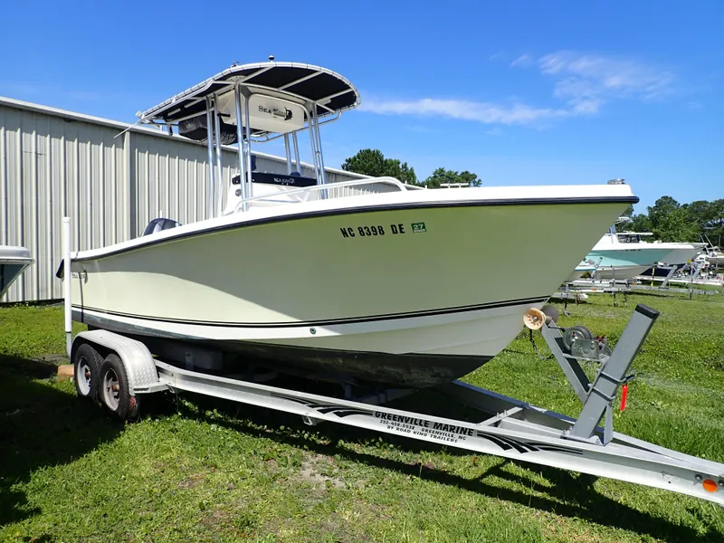 Slide: The Image of 2006 Sea King 210CC boat on trailer, parked outdoors near a metal building. - 0
