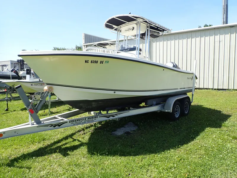 Slide: The Image of 2006 Sea King 210CC boat on trailer, parked on grass near a building. - 1